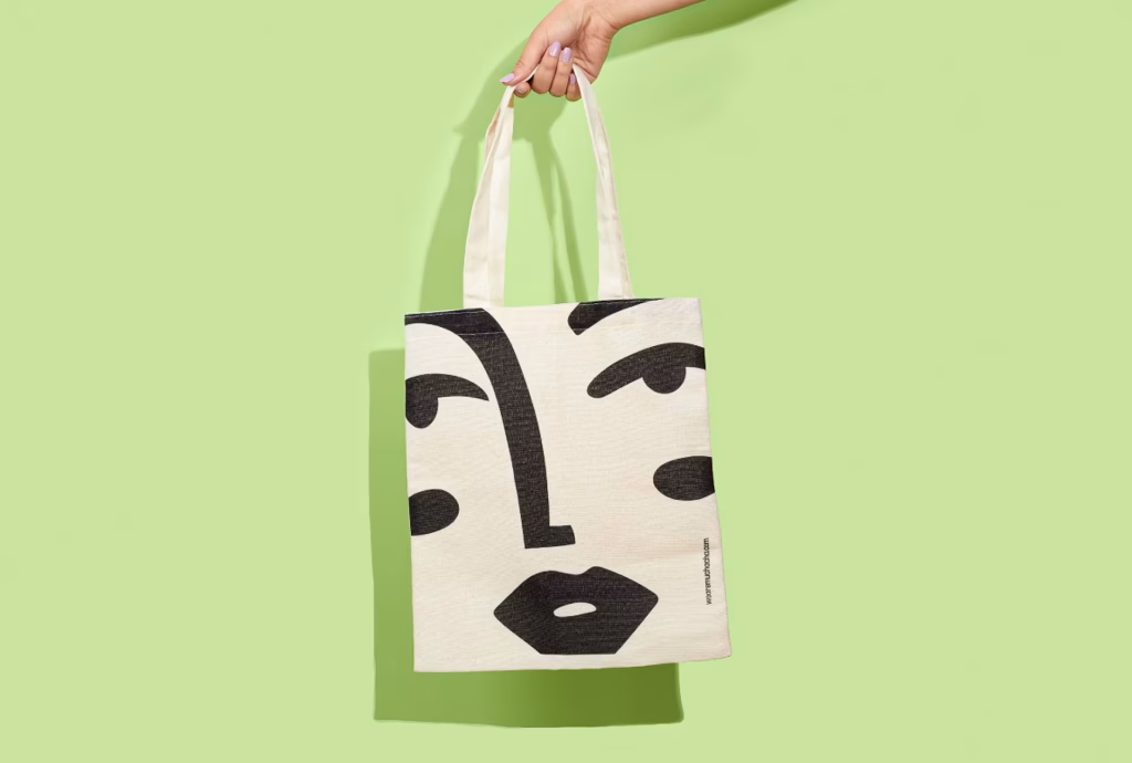 Bolsa de color blanca con ilustración de un rostro de la marca Muchacha