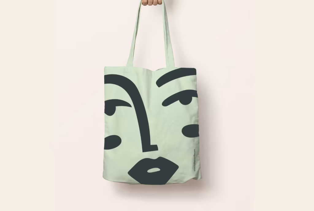 Bolsa de color verde con ilustración de un rostro de la marca Muchacha